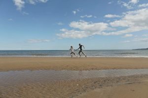 Couple running hand in hand on beach