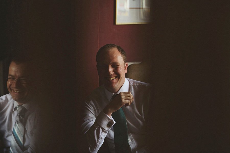Two men in ties laughing indoors