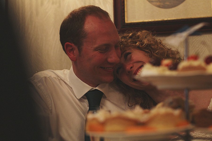 Couple smiling closely at table with desserts