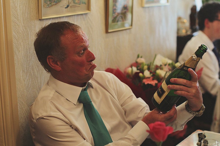 Man examining champagne bottle at dinner table