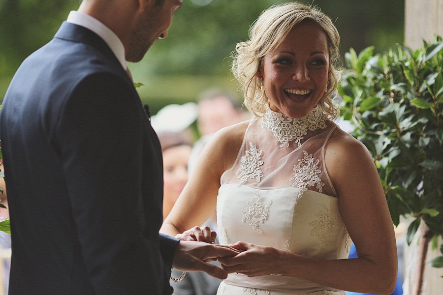 Bride and groom exchanging rings at outdoor wedding.