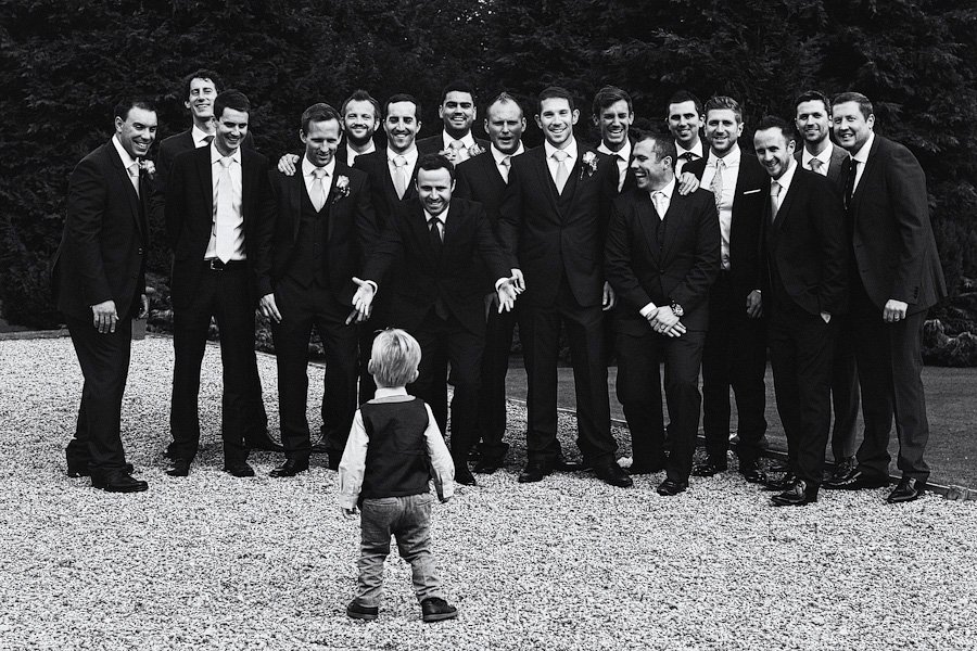 Toddler facing group of suited men outdoors
