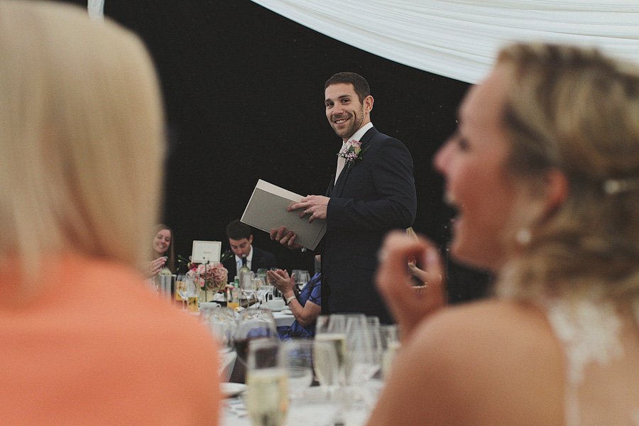Man giving speech at wedding reception table