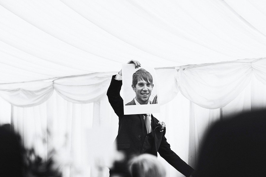 Man holding photo over his face indoors