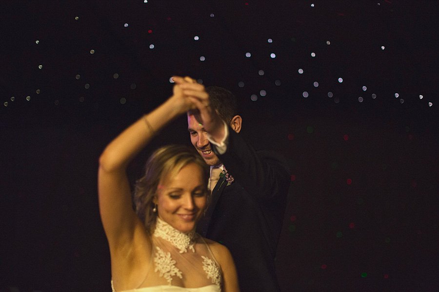 Bride and groom dancing under twinkling lights