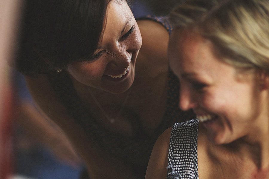 Two women laughing together indoors