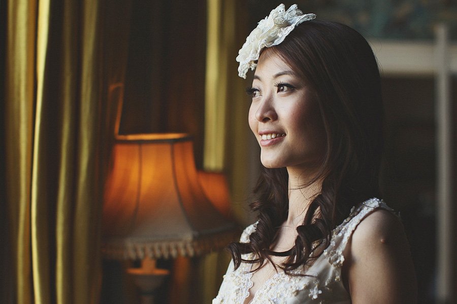 Woman in white dress smiling by window
