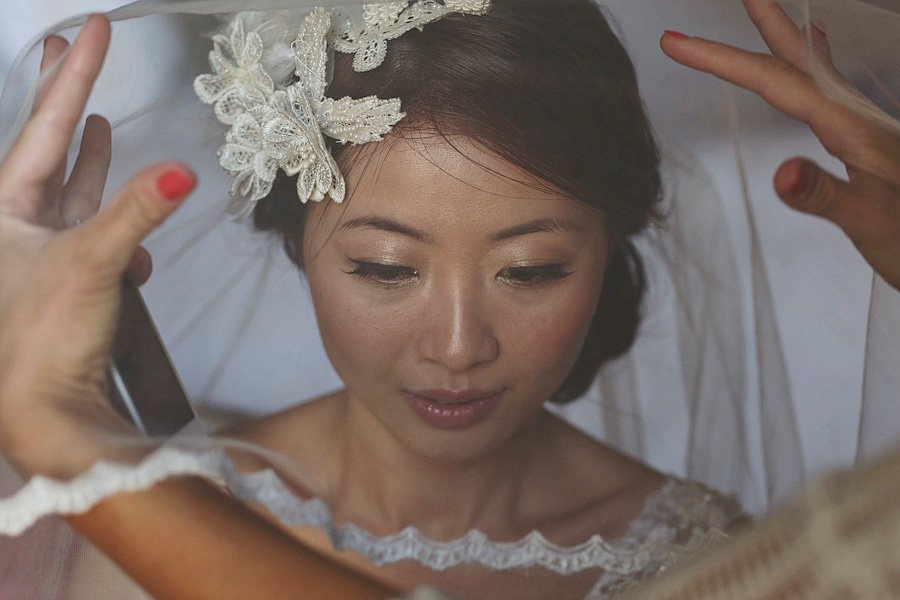 Bride with floral hairpiece adjusting veil