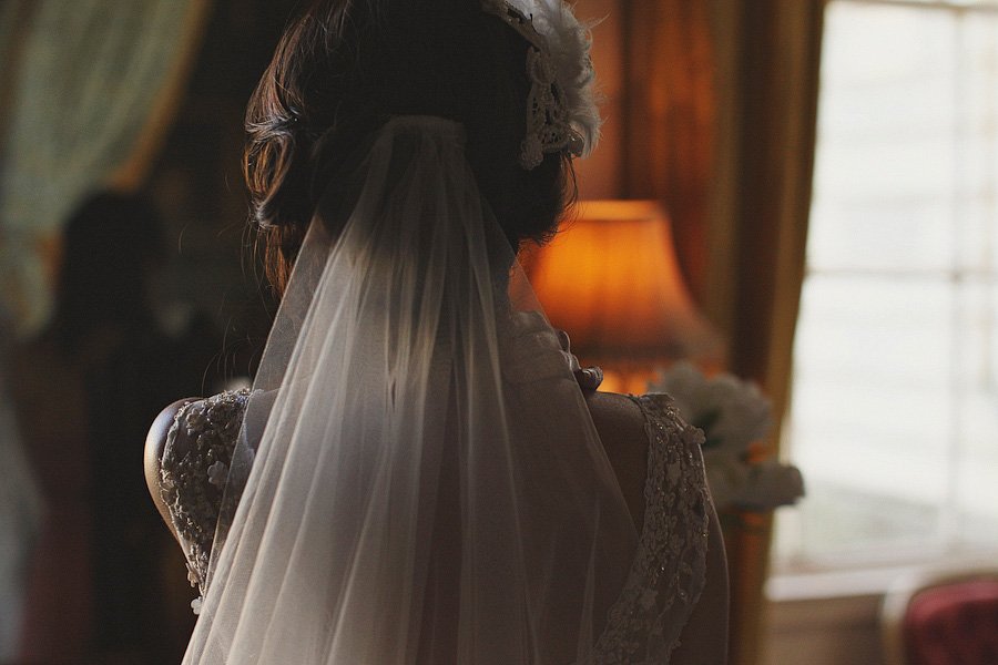 Bride wearing veil in softly lit room