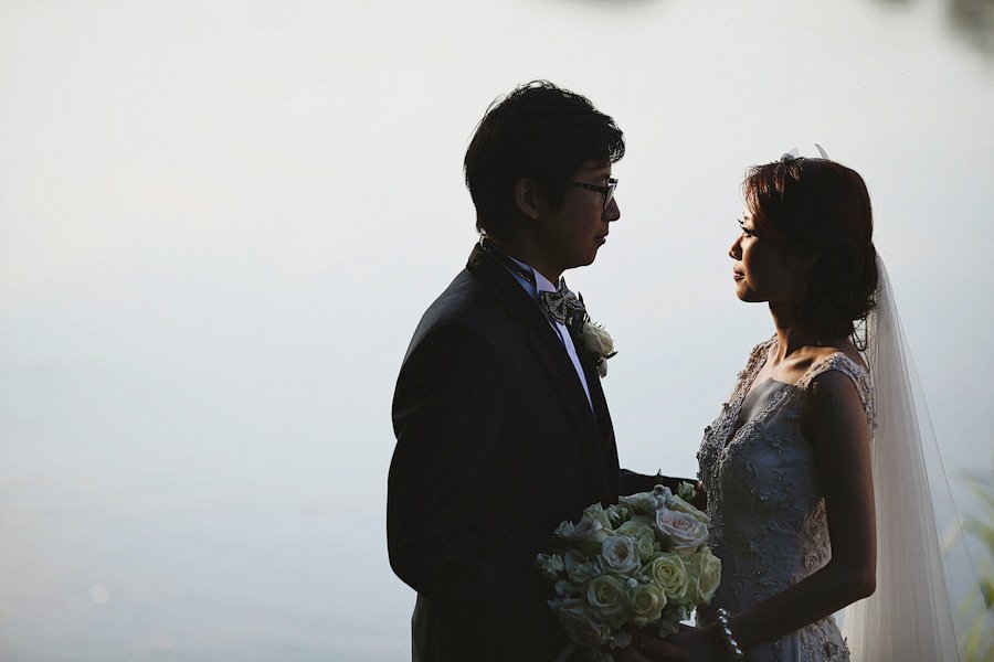 Bride and groom silhouetted at sunset wedding