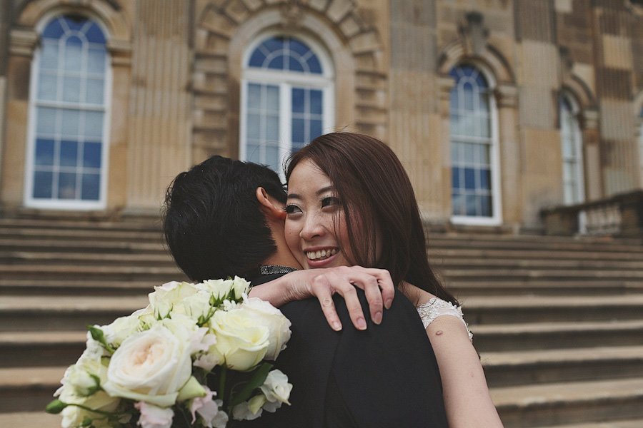 Bride and groom embracing outside historic building