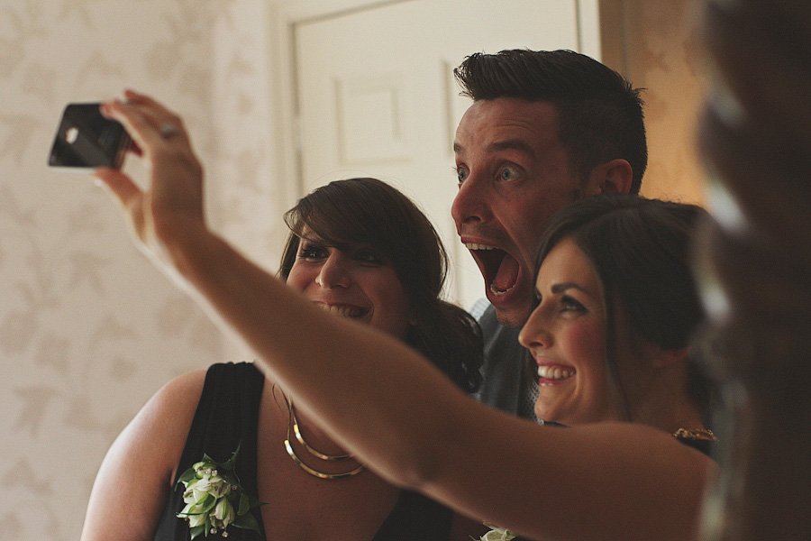 Three friends taking a joyful indoor selfie