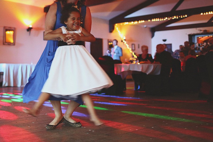 Woman twirling young girl on dance floor