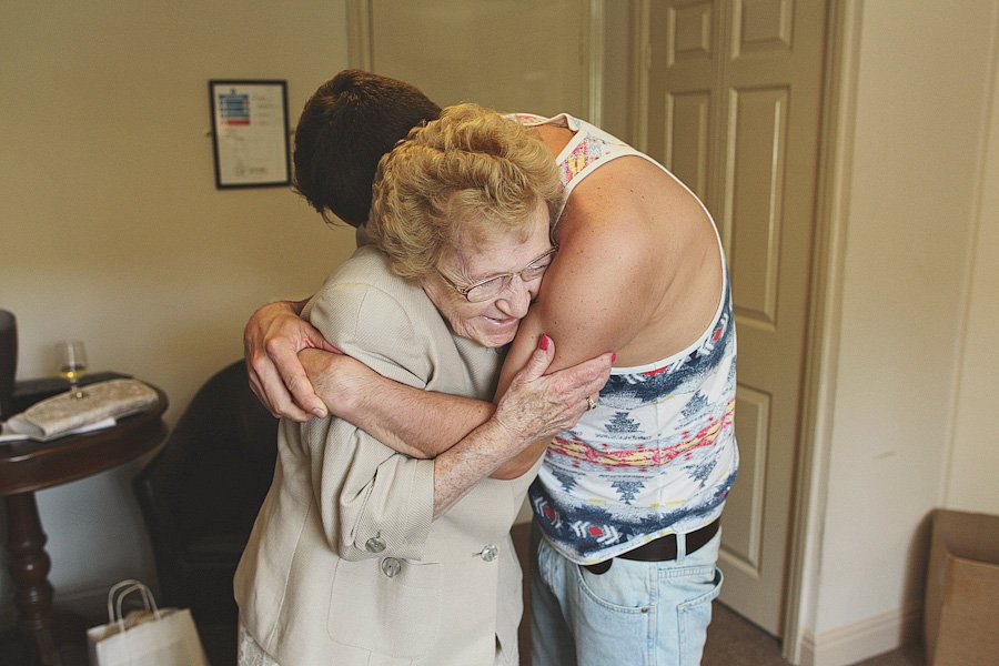 Elderly woman hugging younger man indoors