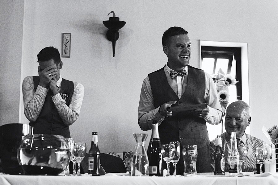 Groom giving emotional wedding speech at reception table
