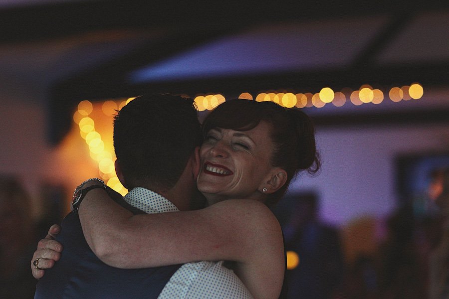 Woman smiling while hugging man at night event