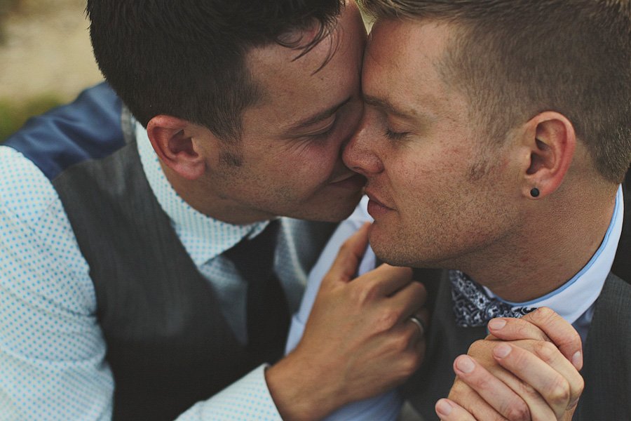 Two men sharing intimate moment in suits