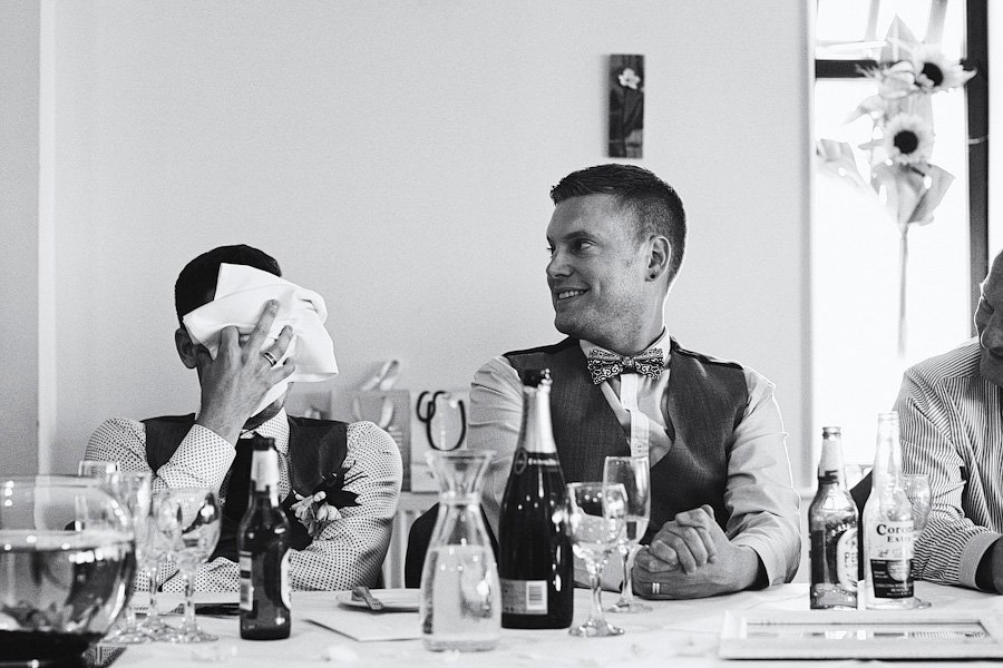 Men laughing at wedding reception table