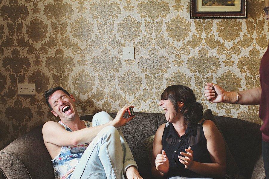 Two friends laughing on couch at home