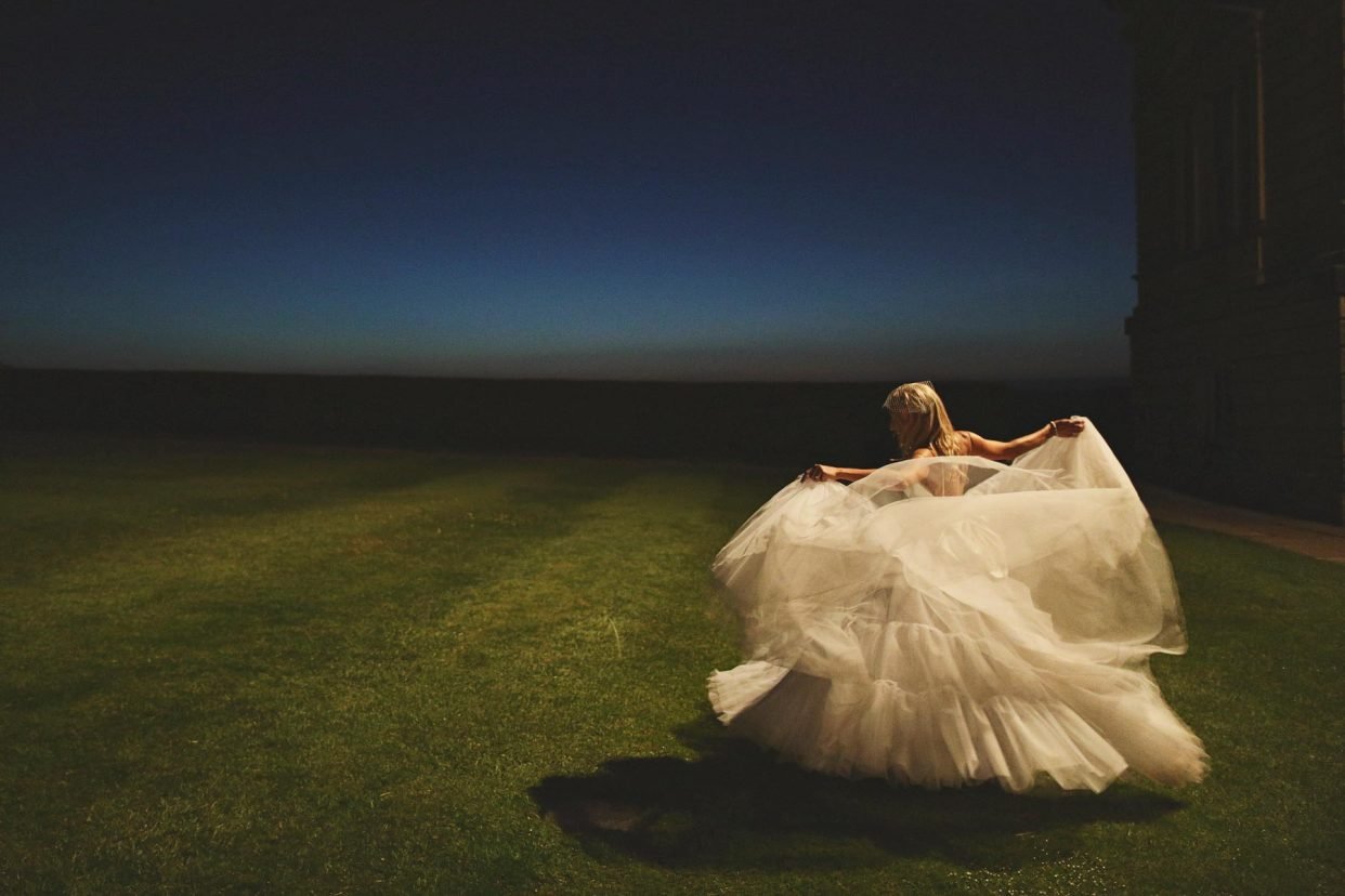 Bride twirling in flowing gown at night