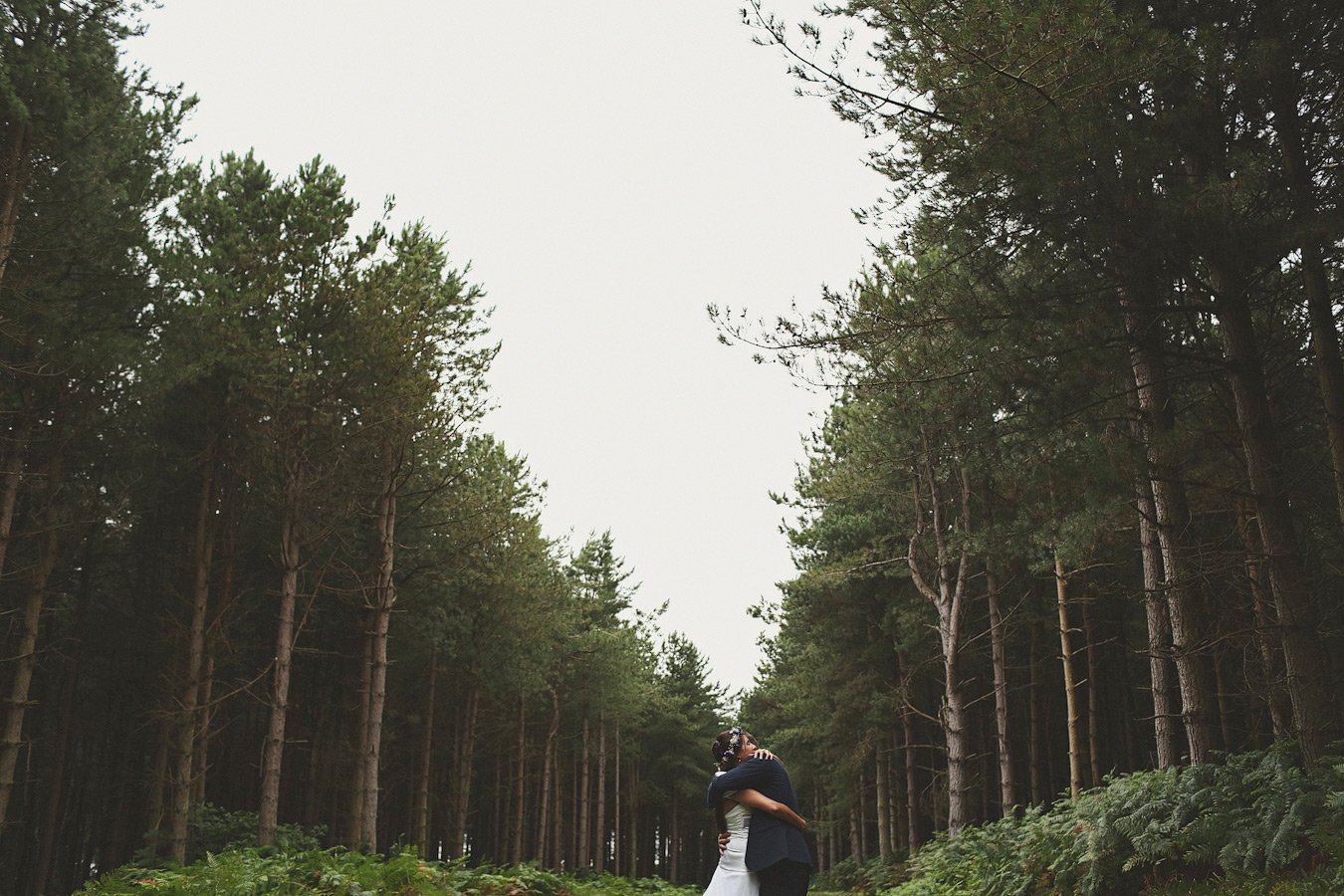 Couple embracing in pine forest clearing