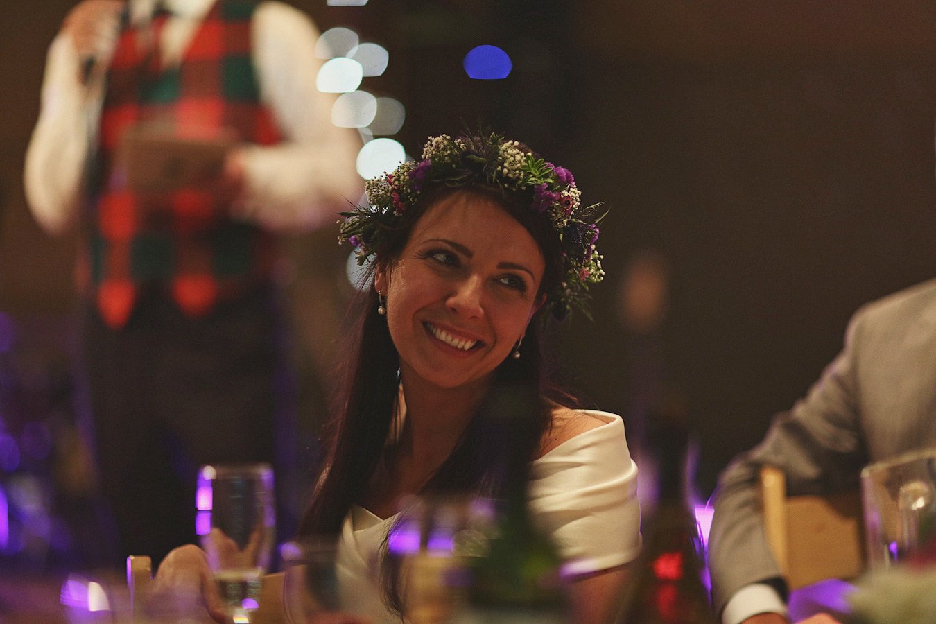 Smiling woman with flower crown at reception table