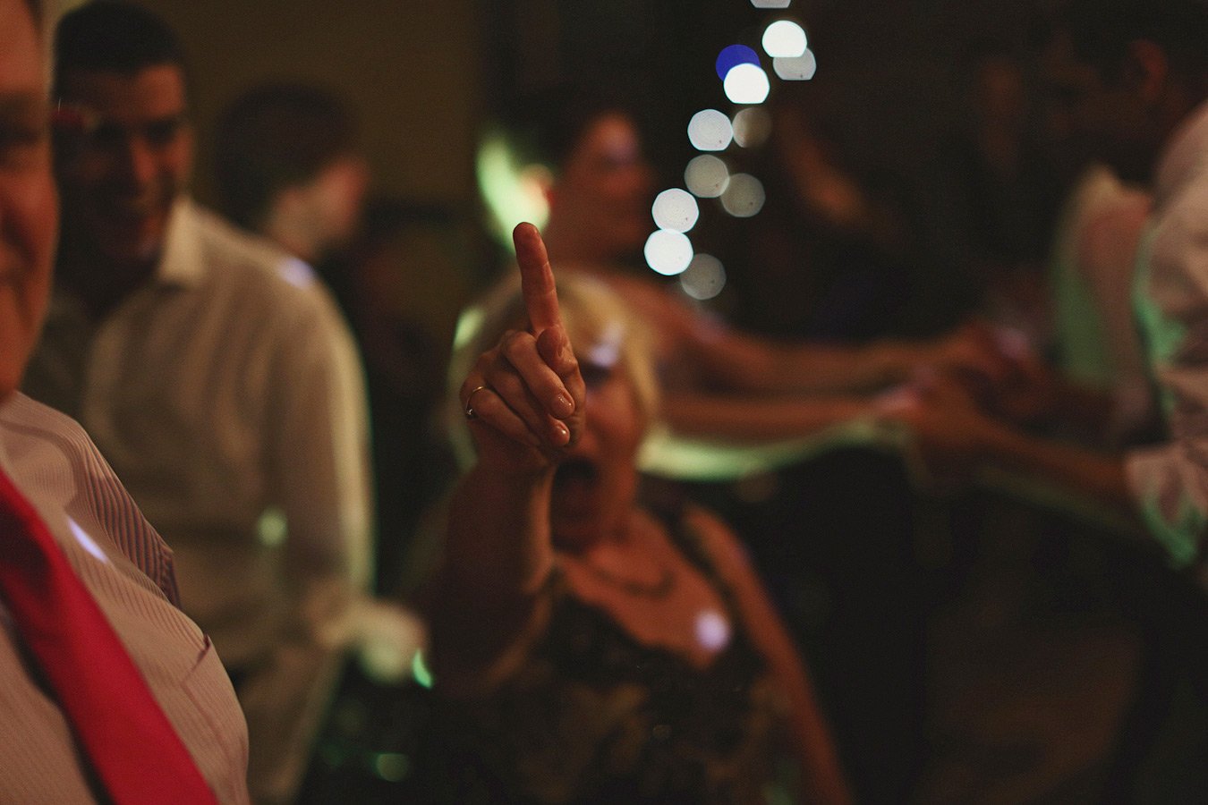 Woman raising finger at dimly lit party