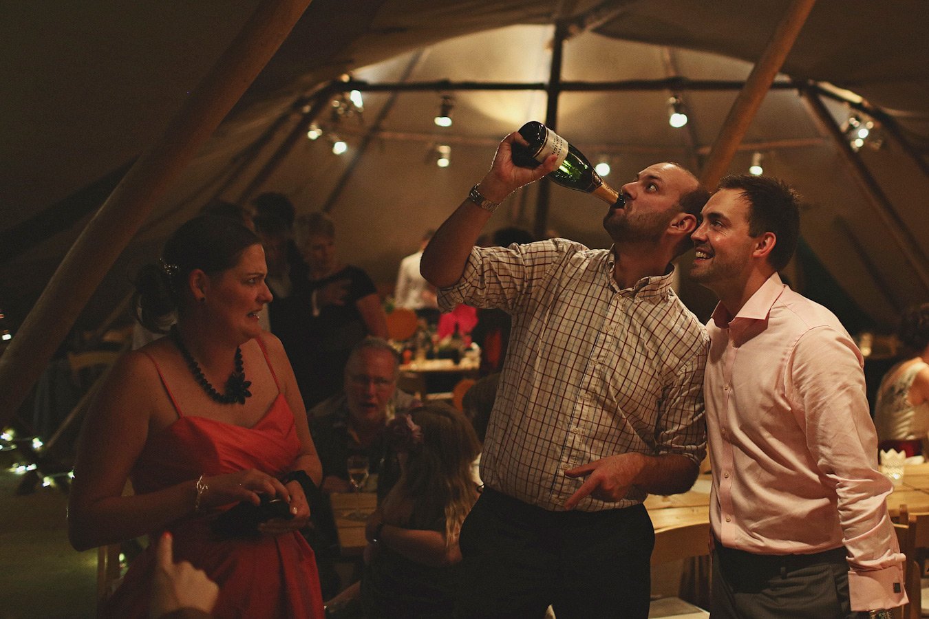 Man drinking champagne at lively indoor party