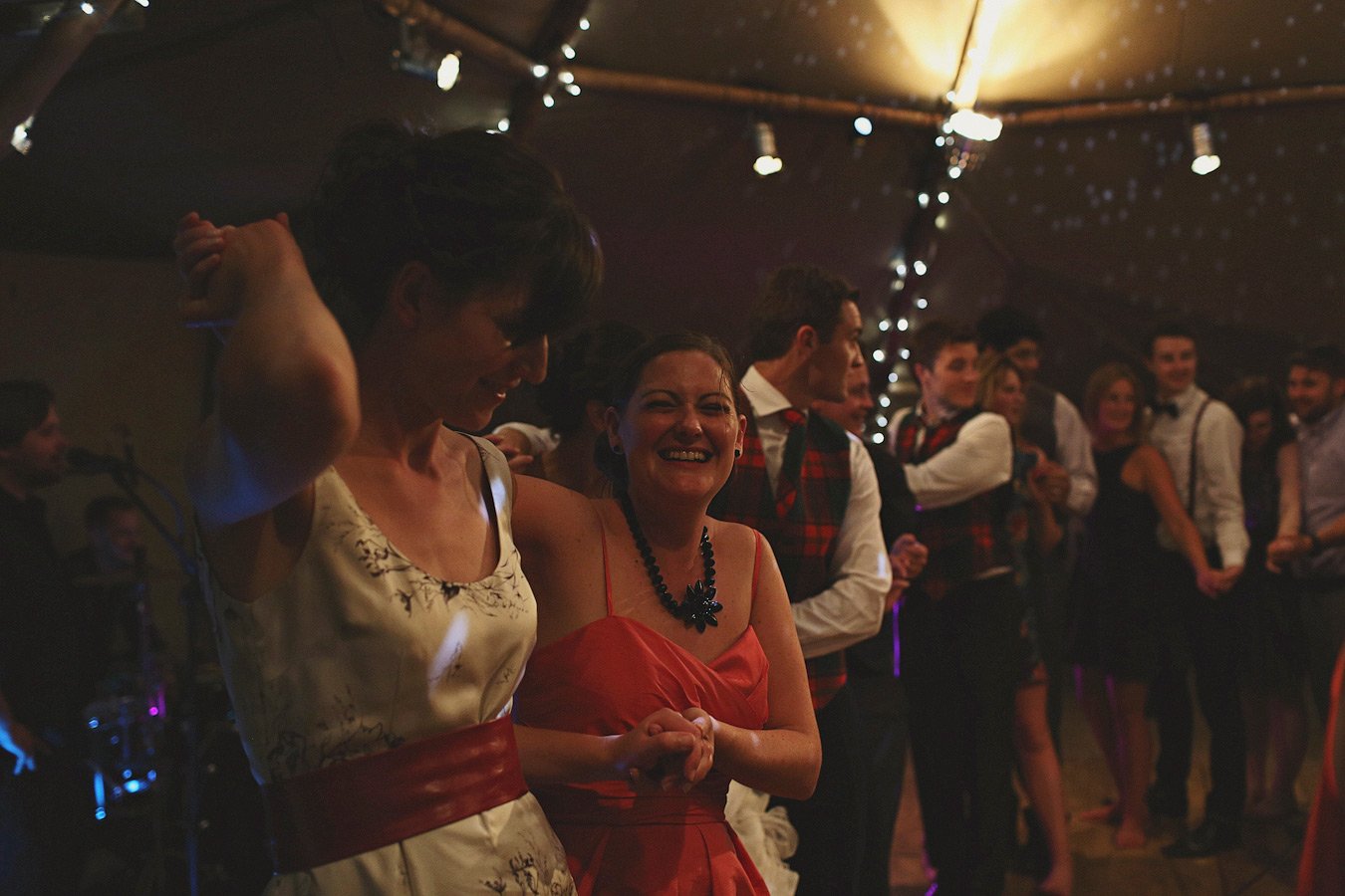 Guests dancing under string lights at party