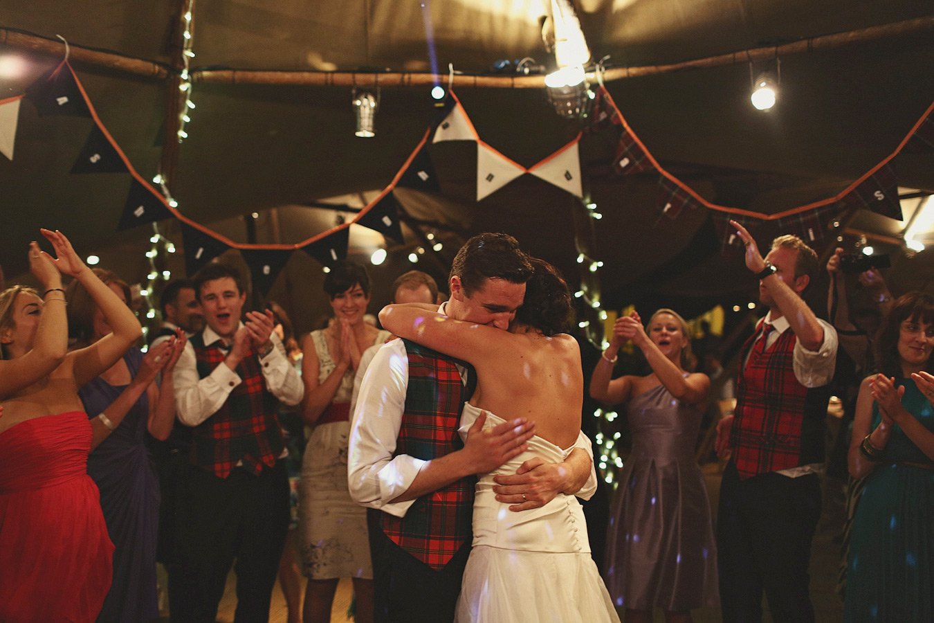 Bride and groom embrace during wedding reception dance