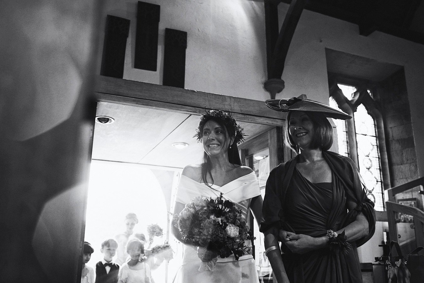 Bride entering church with bouquet and mother
