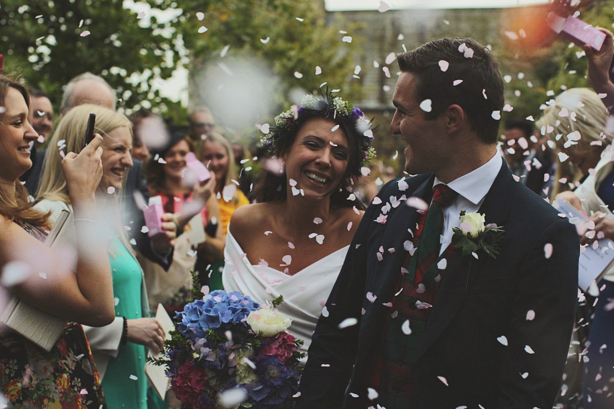 Bride and groom walking through confetti shower