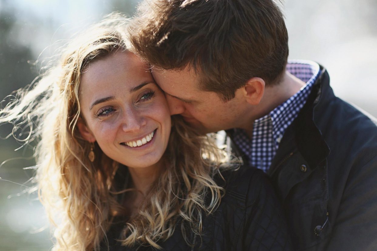 Man kissing smiling woman outdoors