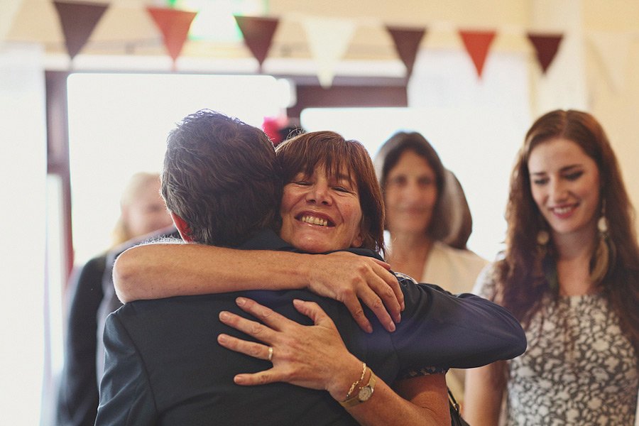 Woman warmly hugging man at indoor celebration