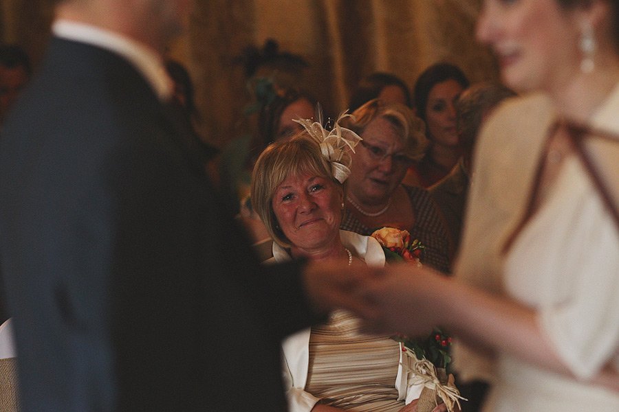 Emotional wedding guest watching ceremony indoors