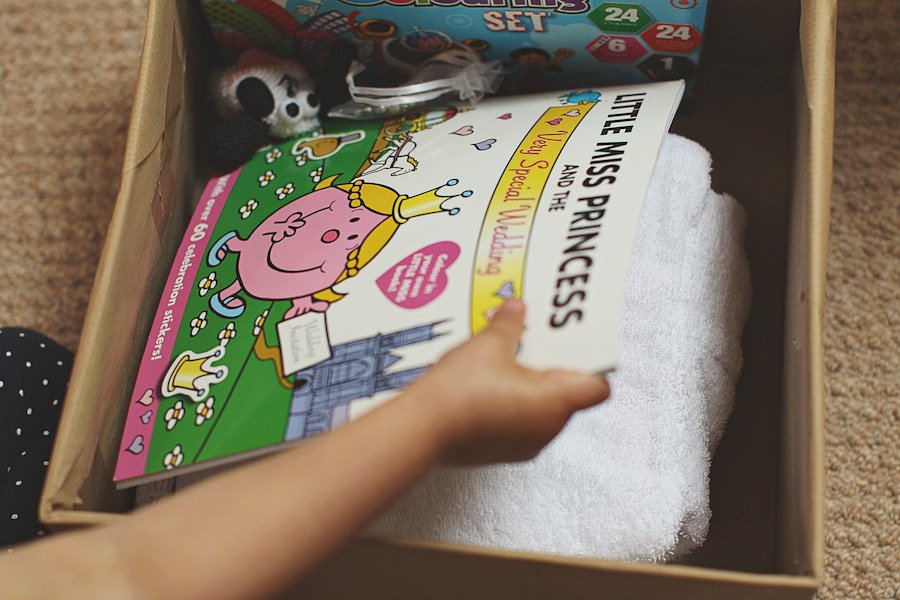 Child placing princess book into gift box