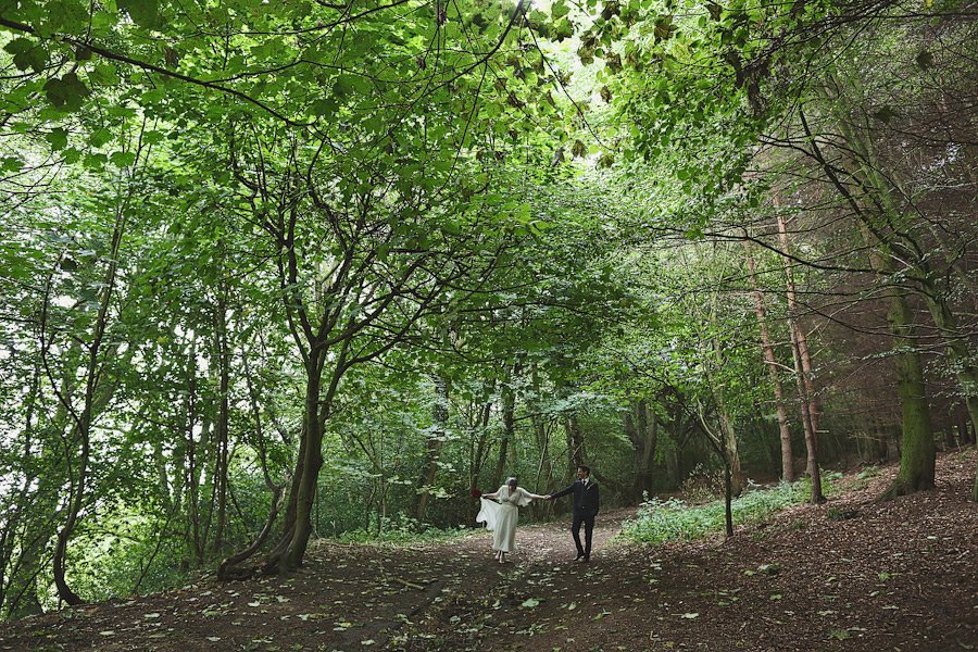 Bride and groom walking in lush forest