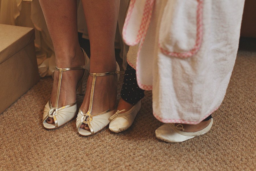 Adult and child standing in dress shoes indoors