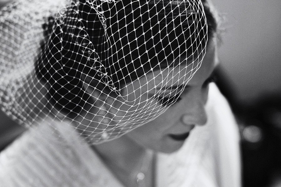 Black-and-white close-up of bride wearing birdcage veil