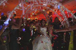 Bride and groom celebrating under falling confetti