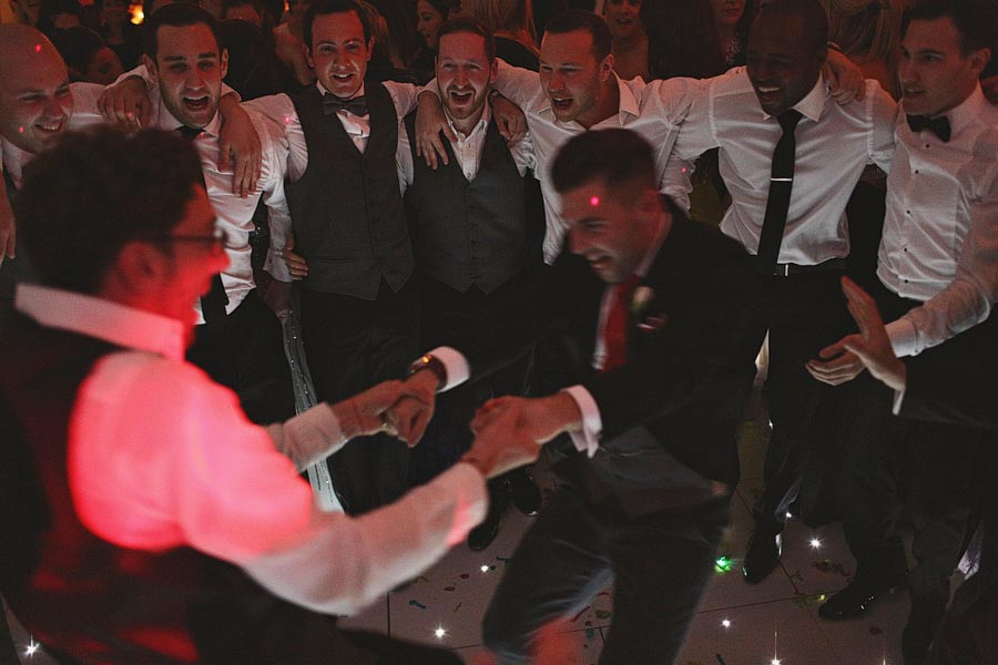 Groomsmen dancing energetically at wedding reception