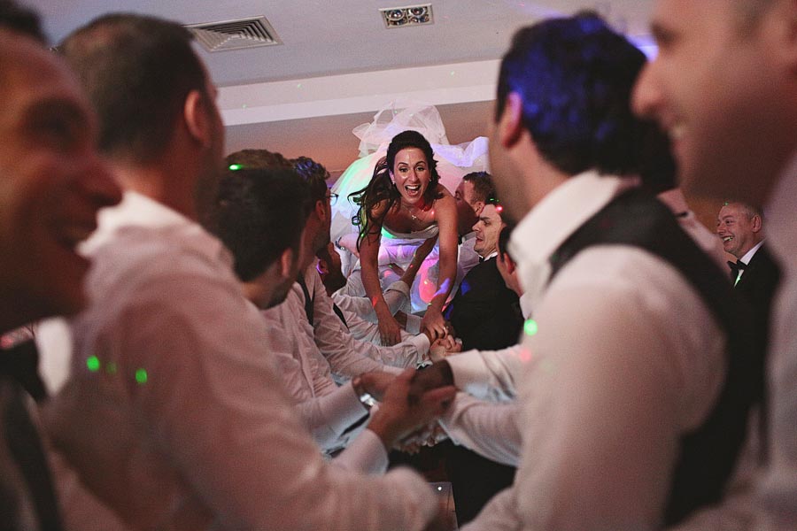 Bride crowd surfing at wedding reception celebration