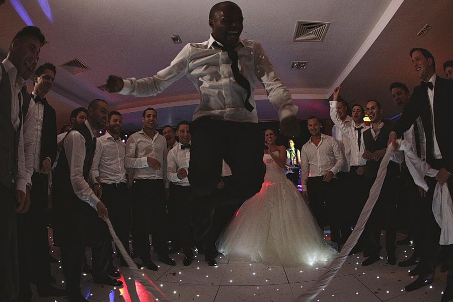 Man jumping over cloth at wedding reception