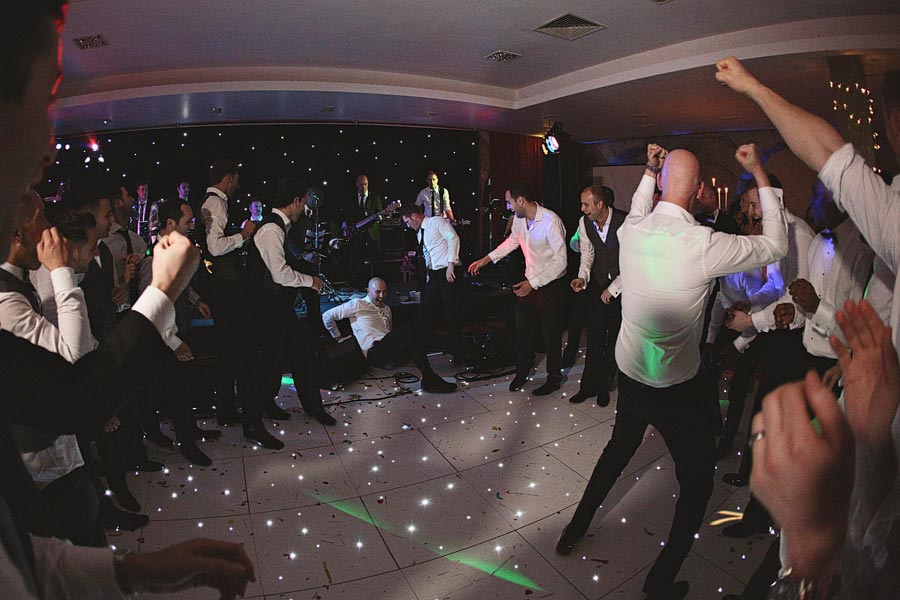 Men dancing energetically at party with live band