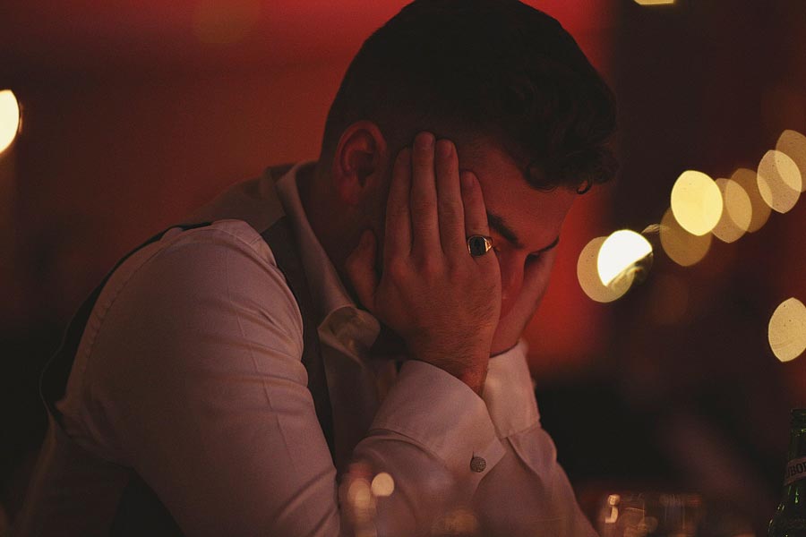 Man sitting at table with head in hands