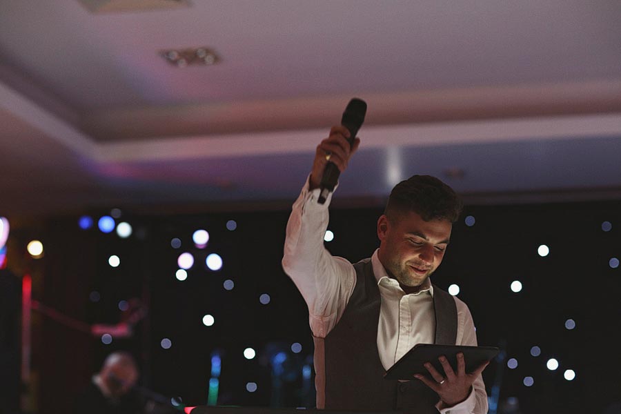 Man holding microphone and tablet on stage