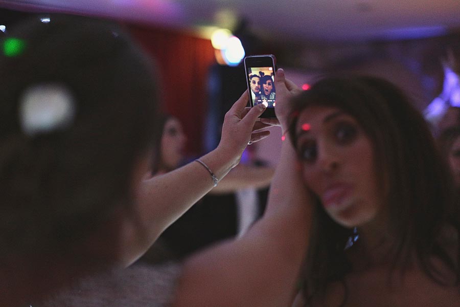 Woman taking selfie at dimly lit party