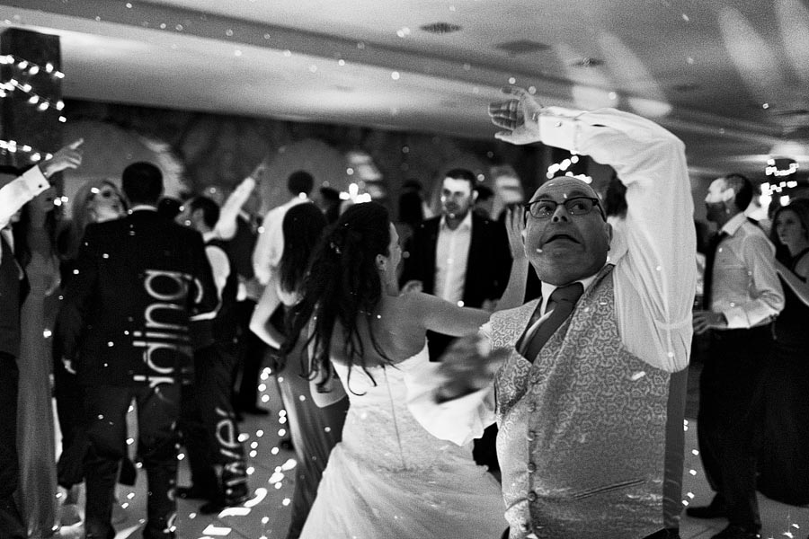 Wedding guests dancing energetically at reception