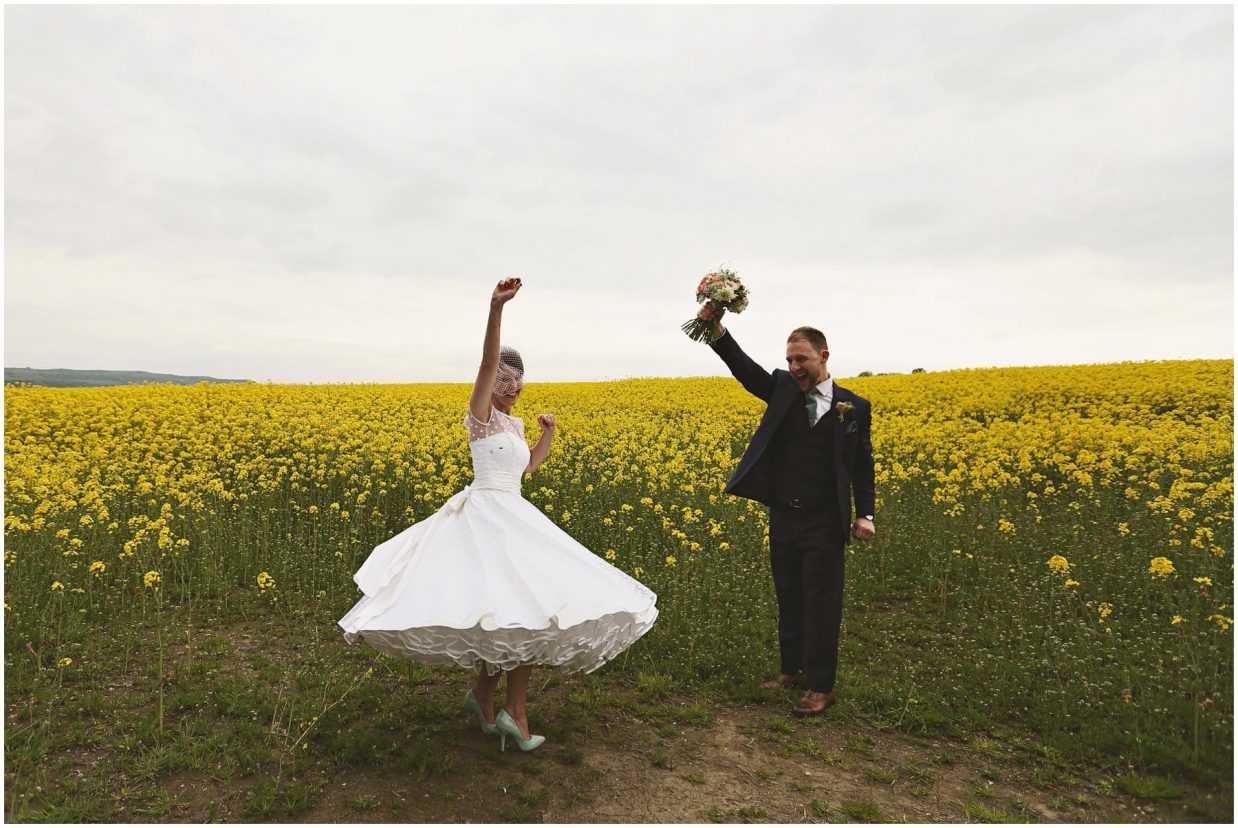 Bride and groom celebrating in yellow flower field