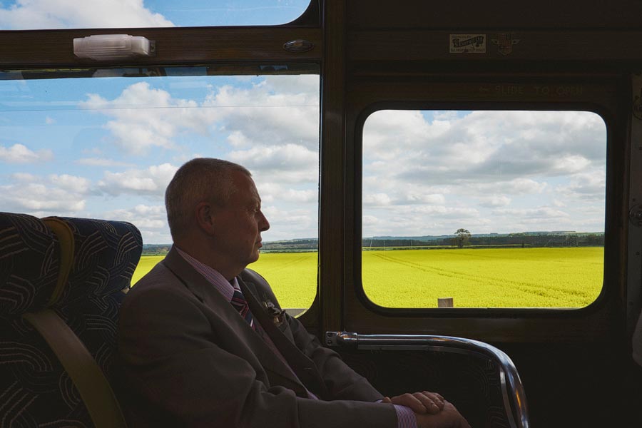 Man in suit looking at countryside from train